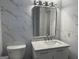 Modern bathroom features white marble-style tiling, a sleek vanity with marble countertop, and updated fixtures at 10875 Shagbark Trl, Roswell, GA 30075