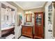 Bathroom with hardwood floors, wood vanity, storage cabinet, and a soaking tub at 10875 Shagbark Trl, Roswell, GA 30075