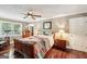 Bedroom with hardwood floors, ceiling fan, and patchwork quilt on the bed at 10875 Shagbark Trl, Roswell, GA 30075