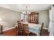 Charming dining room with hardwood floors, floral tablecloth, and a classic wood china cabinet at 10875 Shagbark Trl, Roswell, GA 30075