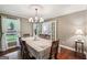 Traditional dining room with hardwood floors, a patterned tablecloth, and chandelier lighting at 10875 Shagbark Trl, Roswell, GA 30075