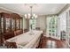 Dining room featuring hardwood floors, elegant lighting, and access to the porch at 10875 Shagbark Trl, Roswell, GA 30075