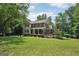 Charming two-story home with a welcoming front porch and a well-manicured lawn at 10875 Shagbark Trl, Roswell, GA 30075