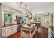 Kitchen with stainless appliances, hanging pot rack, and breakfast nook with hardwood floors and backyard views at 10875 Shagbark Trl, Roswell, GA 30075
