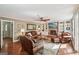 Spacious living room with leather furniture, a brick fireplace, and built-in shelving at 10875 Shagbark Trl, Roswell, GA 30075