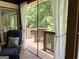 Relaxing screened-in porch features a comfortable chair and beautiful views of the wooded backyard at 10875 Shagbark Trl, Roswell, GA 30075