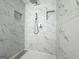 Modern shower features white marble-style tiling, a rainfall shower head, and convenient recessed shelves at 10875 Shagbark Trl, Roswell, GA 30075