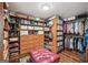 Walk-in closet with custom wooden storage, shelving and a ruby-red bench at 10875 Shagbark Trl, Roswell, GA 30075
