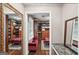 Spacious walk-in closet with built-in shelving, wooden floors and a ruby-red bench at 10875 Shagbark Trl, Roswell, GA 30075