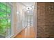 Hallway with hardwood floors, large windows, and a brick wall at 1977 Kensington High Sw St, Lilburn, GA 30047