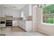 Well-lit kitchen with white cabinetry, stainless steel appliances, and a view to the backyard at 1977 Kensington High Sw St, Lilburn, GA 30047