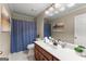 Bathroom with a wood vanity, a white sink, a large mirror, and a shower curtain at 607 Lees Mill Rd, Fayetteville, GA 30214
