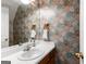 Bathroom with colorful patterned wallpaper, a white countertop, and a mirrored wall at 607 Lees Mill Rd, Fayetteville, GA 30214