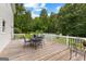 Relaxing outdoor deck with a dining table and chairs overlooking the lush backyard and pool at 607 Lees Mill Rd, Fayetteville, GA 30214