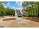 Spacious driveway with view of two story home, pool area and mature landscaping at 607 Lees Mill Rd, Fayetteville, GA 30214