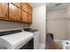 Functional laundry room with Whirlpool washer/dryer and built-in storage cabinets at 607 Lees Mill Rd, Fayetteville, GA 30214