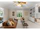 Comfortable living room featuring a leather sofa, ceiling fan, and views to sunroom at 607 Lees Mill Rd, Fayetteville, GA 30214