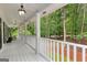Spacious covered porch features white railings, classic lighting, and scenic wooded views at 607 Lees Mill Rd, Fayetteville, GA 30214