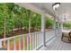 Inviting covered porch with white railing overlooks lush greenery and wood views at 607 Lees Mill Rd, Fayetteville, GA 30214