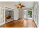 Hardwood floors, large windows, and decorative fan in a sunroom filled with light, leading to another room at 607 Lees Mill Rd, Fayetteville, GA 30214