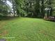 Spacious backyard features a deck and mature trees at 115 Lakeview Dr, Stockbridge, GA 30281