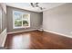 Bonus room features hardwood floors, a ceiling fan, and a large window overlooking the backyard at 335 Canvasback Trl, Locust Grove, GA 30248