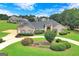 Beautiful single-story home with a circular driveway, manicured lawn and lush landscaping at 335 Canvasback Trl, Locust Grove, GA 30248