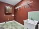 Laundry room includes a utility sink, overhead rack, tile floor, and a storage cabinet at 335 Canvasback Trl, Locust Grove, GA 30248