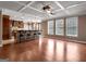 Open-concept living space with hardwood floors, coffered ceiling, and bar-style seating at 335 Canvasback Trl, Locust Grove, GA 30248