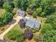 Overhead shot showcasing a property with mature trees, well-maintained lawn, detached garage, and a long, private drive at 135 Acorn Dr, Mcdonough, GA 30253