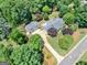 Aerial view of a property with lush landscaping, mature trees, a private driveway, and a detached garage at 135 Acorn Dr, Mcdonough, GA 30253
