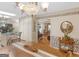 Charming dining room with a wood table, decorative wallpaper, chandelier, and an open view into the living area at 135 Acorn Dr, Mcdonough, GA 30253
