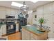 Functional kitchen featuring white cabinets, a central island with a green countertop, and black appliances at 135 Acorn Dr, Mcdonough, GA 30253