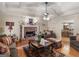 Cozy living room featuring a brick fireplace, comfortable seating, hardwood floors, and a view into the dining room at 135 Acorn Dr, Mcdonough, GA 30253