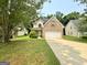Traditional brick-accented home featuring an attached two-car garage and a well-manicured front lawn at 105 Avonwood Cir, Locust Grove, GA 30248