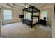 Spacious main bedroom with neutral carpet, a four-poster bed, ceiling fan and two windows at 105 Avonwood Cir, Locust Grove, GA 30248