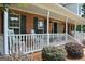 Inviting front porch with rocking chairs, brick accents, and views of the landscaped yard at 500 Hayfield Ct, Locust Grove, GA 30248