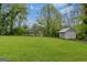 Large, grassy backyard with mature trees and a storage shed, offering ample space at 109 Stockbridge Rd, Jonesboro, GA 30236
