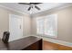 Well-lit office space with a ceiling fan, hardwood floors, and a large desk at 109 Stockbridge Rd, Jonesboro, GA 30236