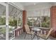 Enclosed porch featuring brick columns, concrete floor, and a seating area with chairs and table at 109 Stockbridge Rd, Jonesboro, GA 30236