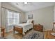 Cozy bedroom with natural light, a twin-sized bed, wood floors, and a vintage-style trunk at 1025 Pinehurst Dr, Peachtree City, GA 30269