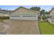 Attached two-car garage with white doors and a long concrete driveway at 1025 Pinehurst Dr, Peachtree City, GA 30269