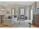 Bright living room featuring hardwood floors, high ceilings, and a cozy seating area with decorative pillows at 1025 Pinehurst Dr, Peachtree City, GA 30269