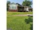 Covered back porch on two-story brick and white siding home with greenery at 619 E College St, Bowdon, GA 30108