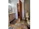 Cozy bathroom with a vanity, slate floors, and a partially opened wooden door at 619 E College St, Bowdon, GA 30108