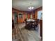 Spacious dining room with wood paneling, hardwood floors, and a charming table with chairs at 619 E College St, Bowdon, GA 30108
