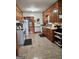 Traditional kitchen showcasing wooden cabinetry, white appliances, and ample counter space for meal preparation at 619 E College St, Bowdon, GA 30108