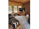 Rustic living room with wood walls, brick accents, comfortable seating, and a decorative rug at 619 E College St, Bowdon, GA 30108