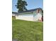 View of white outbuilding with a black metal roof in a yard with green grass and a tree in the background at 619 E College St, Bowdon, GA 30108