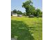 A large grassy lawn with mature trees creating a shaded landscape around the houses in the neighborhood at 619 E College St, Bowdon, GA 30108